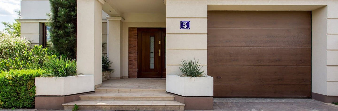 Worldwide Delivery: Brown modern facade of a home with a blue porcelain enamel sign