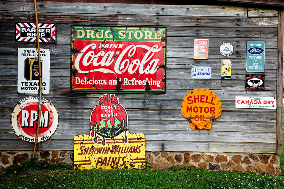 Beer signs: Metal advertising signs hung on a wooden wall